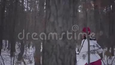 穿着温<strong>暖</strong>衣服的非裔美国女孩戴着一顶红色帽子、围巾和白色夹克穿过<strong>冬季</strong>森林。 美丽美丽